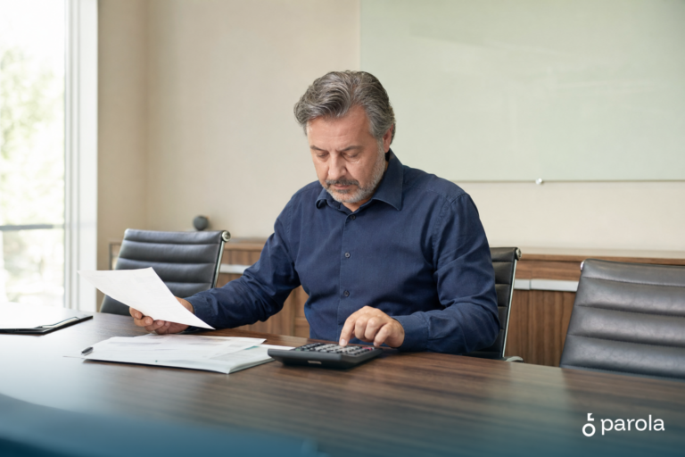KDV nasıl hesaplanır sorusunu inceleyen işletme sahibi, hesap makinesiyle fatura tutarını kontrol ediyor